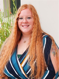 Woman with red hair and green striped shirt 