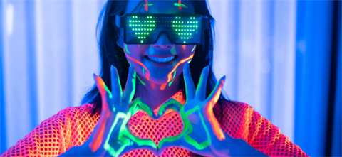girl in the dark with neon lights holding hands in heart shape